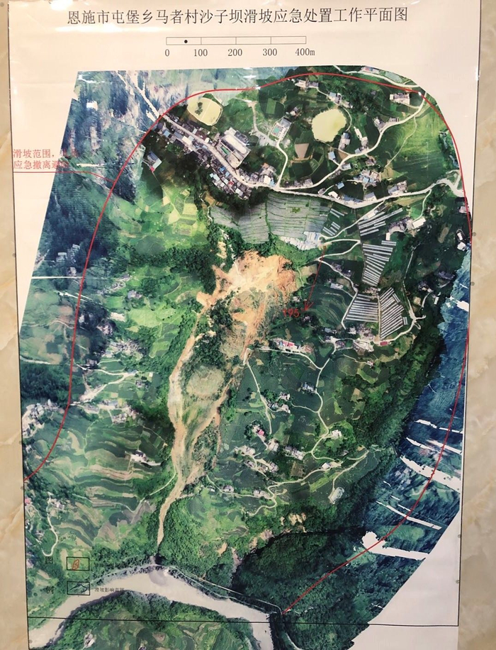 7月23日，挂在村委会办公室的滑坡航拍图，危险区域用红线标出。新京报记者 向凯 摄