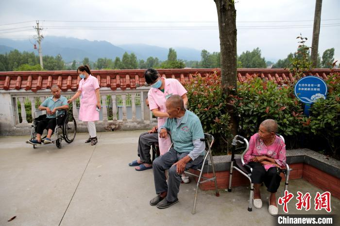 图为养护中心的护理人员在照顾失能、半失能人员。　张远 摄