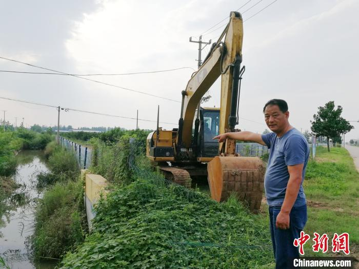 前一天深夜突下暴雨，村书记带领村干部们连夜在桃园里排洪放水，直至清晨。　朱志庚 摄