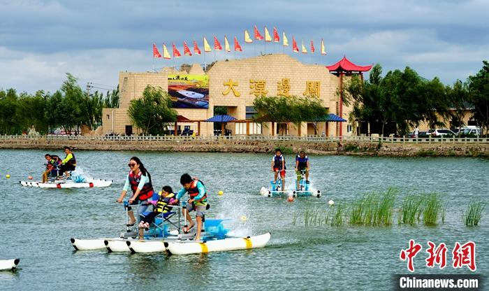资料图为宁夏中卫沙坡头景区，游客体验水上项目。 中新社发 中卫市委宣传部 供图