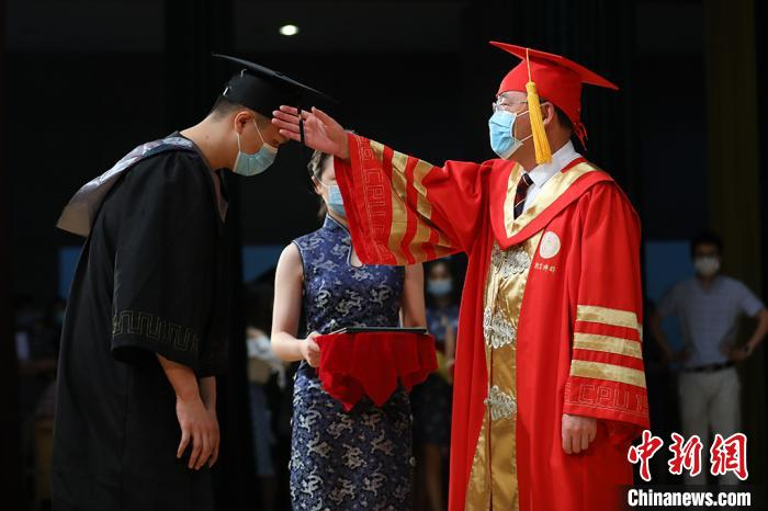 中国药科大学校长来茂德为毕业生代表颁发毕业证书，拨穗正冠授予学位。　泱波 摄