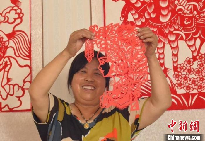 高翠珍展示自己的剪纸作品。　毛宏玉 摄