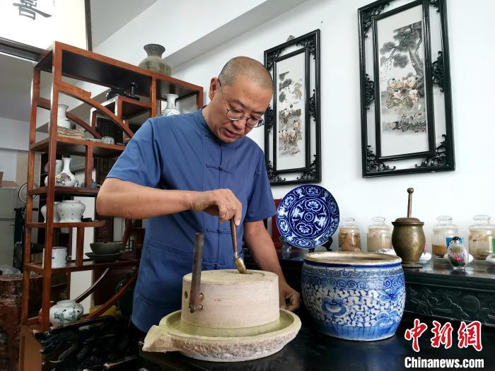 图为王昱将揉碎的原材料进行磨粉。　郝学娟 摄