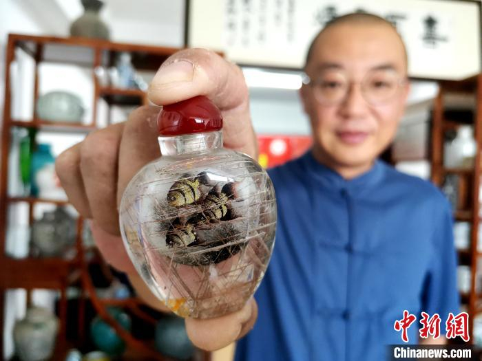 图为王昱展示鼻烟壶。　郝学娟 摄