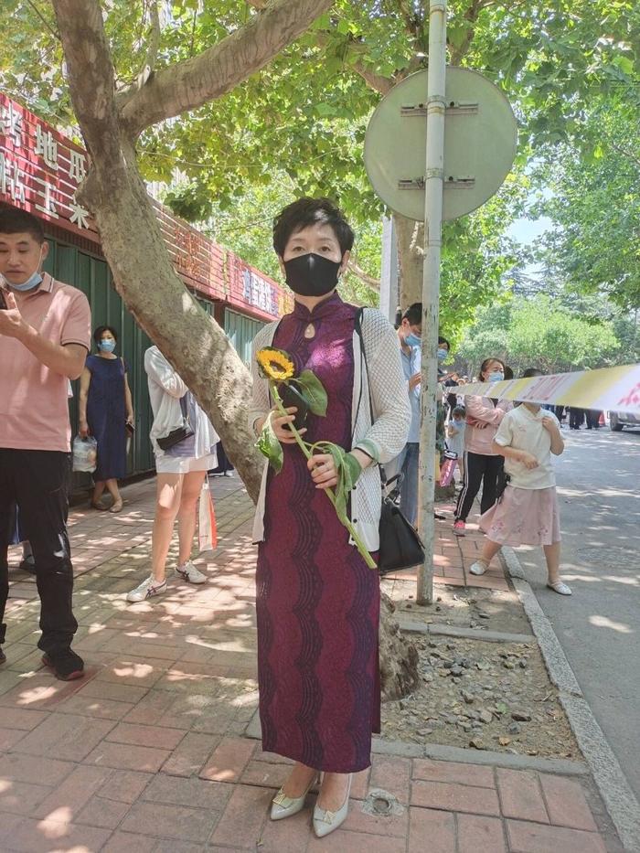 潍坊:一家长穿旗袍举向日葵祝孩子旗开得胜一举夺魁