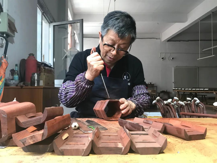琴坊中，工人精心打磨作品。梅村街道供图