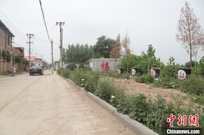 高臾镇四街村，村民将家中弃用的水缸摆放在村口，代替了耗资巨大的牌坊。　王天译 摄