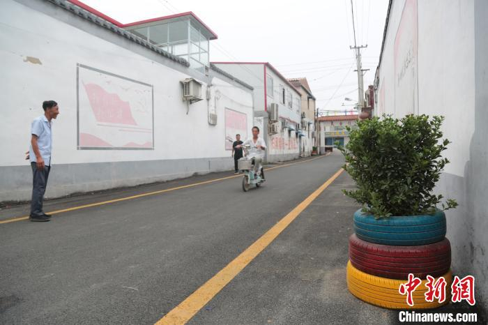 冀南新区林坛镇关庄村，村民将废弃的轮胎制成盆景，摆放在修葺一新的街道上。　王天译 摄