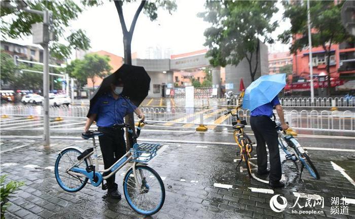 狂风大雨中城管给考生家长送雨衣 暖身又暖心