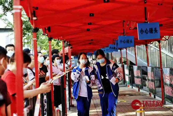  北京人大附中、北大附中以及北京最大考点中关村中学，考场秩序井然，戴着口罩的考生相隔安全距离等待进考场前的测温。（环球时报-环球网记者 李昊/摄）