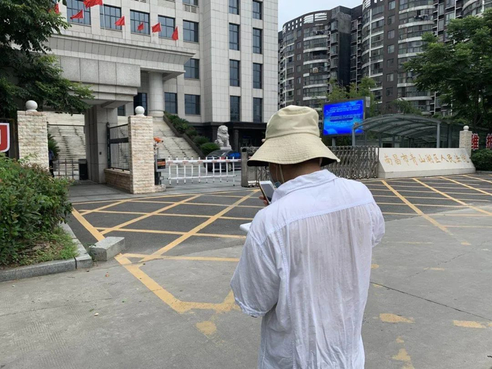 ▲受害人罗伟在南昌市青山湖区法院门口。新京报记者 李阳 摄