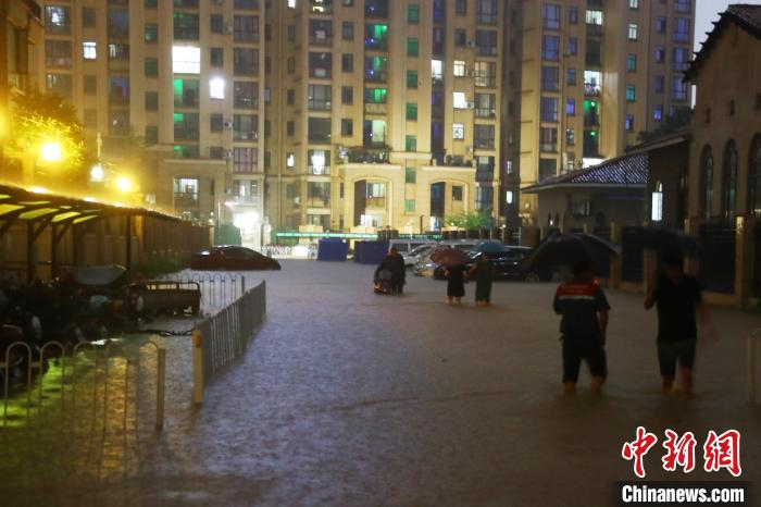 图为江西南昌一小区道路积水严重，民众涉水前行。　刘占昆 摄