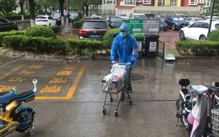 ▲管军冒雨为社区居民送货。受访者供图
