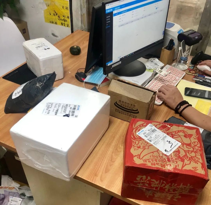 ▲7月18日，肖实办公桌上的问题快件。实习生 杜佳冰 摄