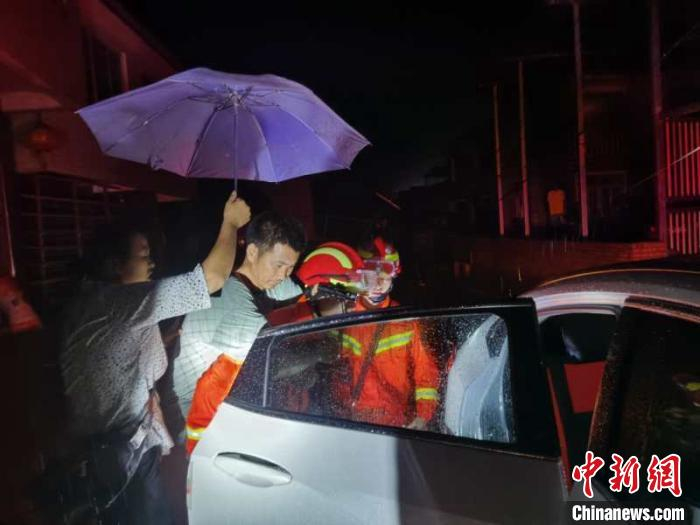 雨中消防救援人员利用车辆转移群众。雅安消防供图