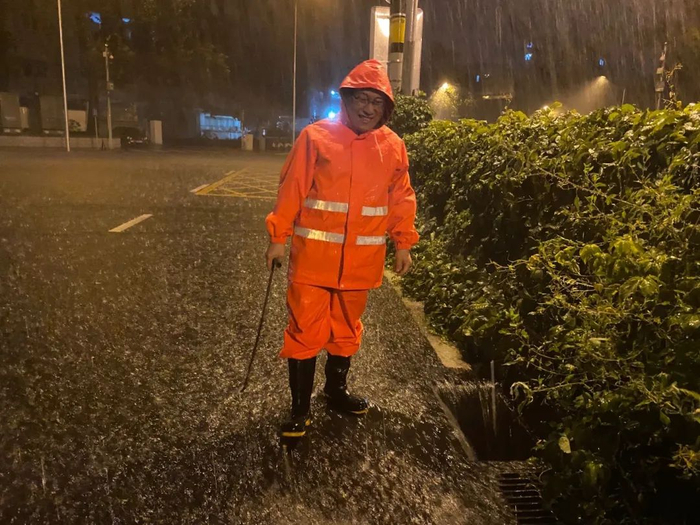 ▲张道平守在打开的雨水箅子前。新京报记者肖薇薇 摄
