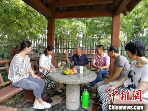 村民围坐话家常 陈爱娣 摄