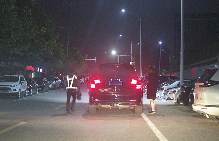 （疑似喝了酒的司机，将车从小胡同开出来停到路边，再叫代驾司机开车。）