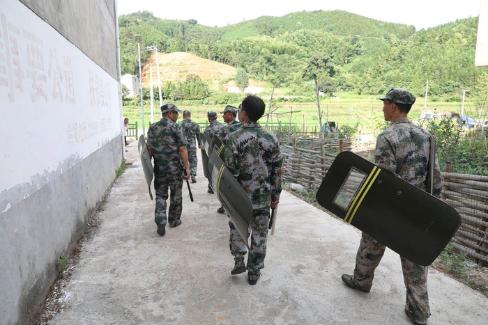 8月15日，厚坊村数公里外的白石村，民兵身穿迷彩服巡逻。新京报记者王飞摄。&nbsp;