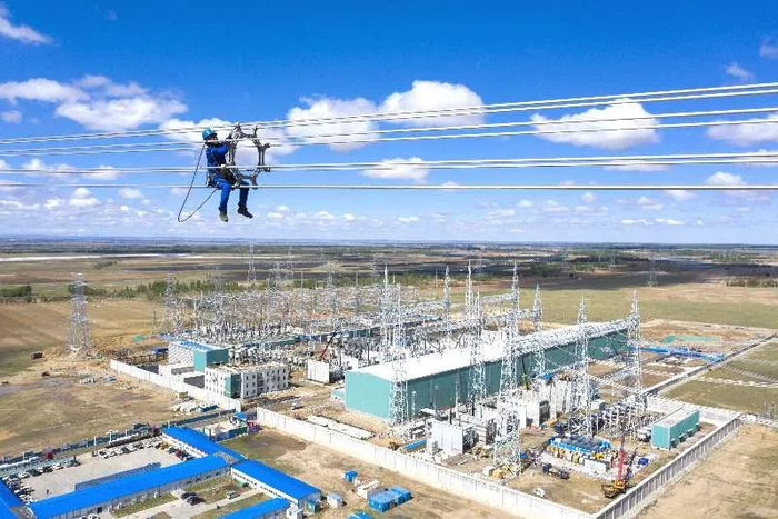 ▲5月27日，张雄线路施工正在紧张进行中，图为工作人员正在对架好的线路进行认真检查消缺。邹明/摄