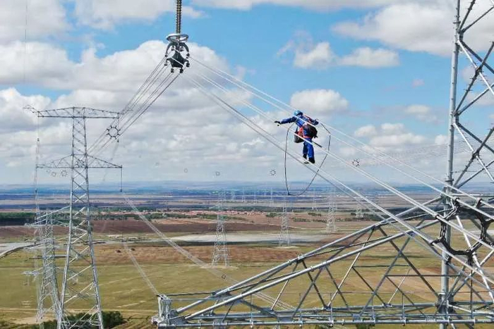 ▲5月29日，国网冀北电力北京送变电公司施工人员在张北-雄安1000千伏特高压输电线路工程进行附件安装。李峥/摄