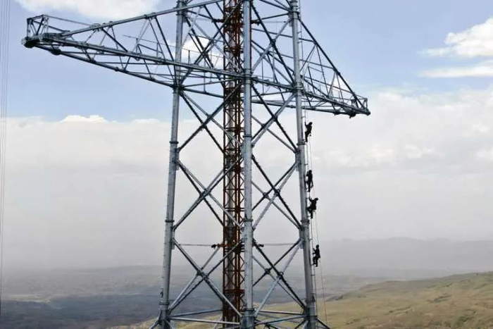 ▲5月28日，国网冀北电力北京送变电公司施工人员在张北-雄安1000千伏特高压输电线路工程排队上塔准备进行铁塔组立。李峥/摄