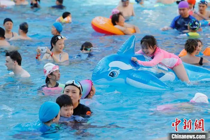 资料图：孩子骑在充气玩具上，在水中嬉戏。殷立勤 摄