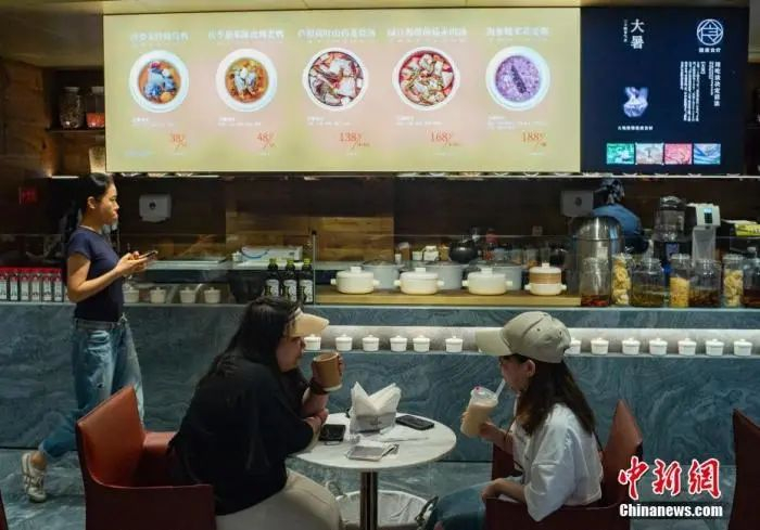 位于北京市朝阳区双井附近的一家“同仁堂知嘛健康”店内，顾客在品尝咖啡、饮料。侯宇 摄