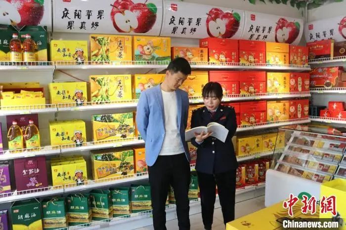 资料图：甘肃庆阳西峰区税务局工作人员到小店讲解最新税费优惠政策。甘肃省税务局供图