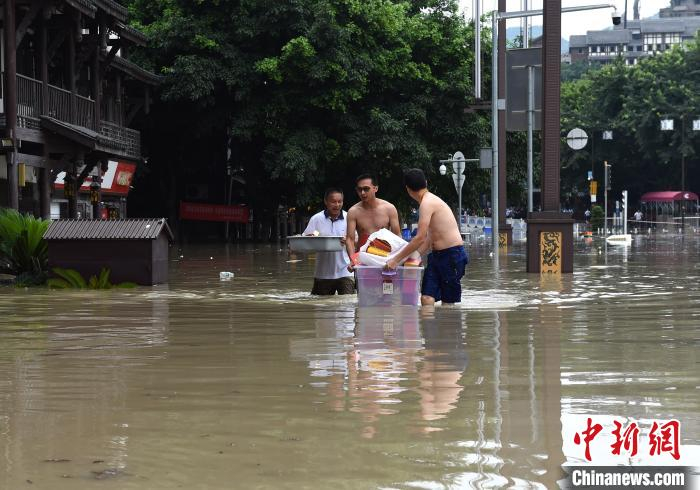 图为市民涉水转移物品。　周毅 摄