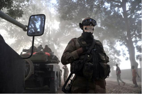 一张著名的照片：直升机扬起风沙，法国士兵用骷髅图案的头巾遮住脸部。（图：法新社）