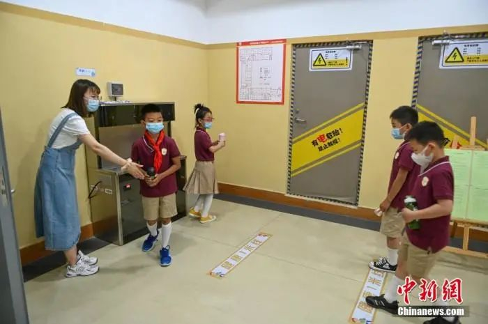 资料图：沈阳市浑南区第十一小学，学生保持一米距离，到饮水机前接水。于海洋 摄