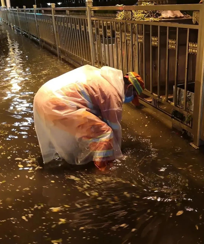 东城环卫在大雨天出动应急抢险队伍，快速进行道路雨水口清理。（资料图）