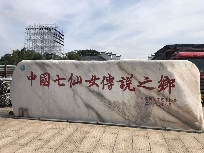 新余仙女湖里的“中国七仙女传说之都”的石碑，后面是2020年8月初正在搭建的央视七夕晚会设施。