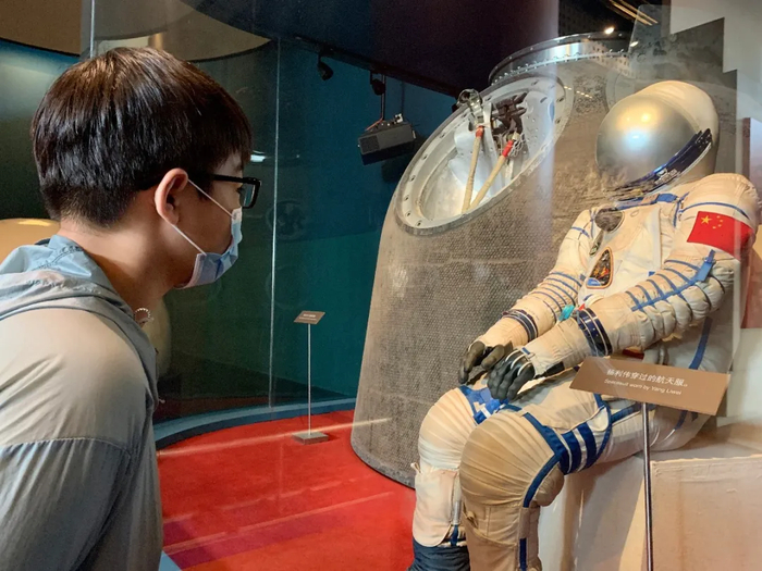 吴式初参观国家博物馆，近距离观看航天员杨利伟曾经穿过的航天服和神舟五号的返回舱。