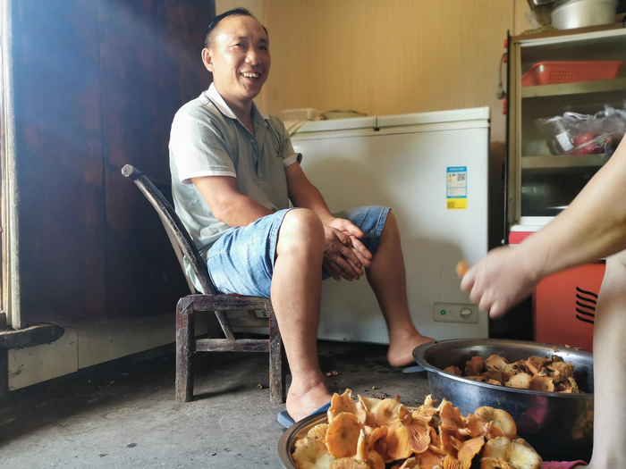 2020年8月1日，谢良华在自家的厨房收拾菌子，这些菌子，都是他在山上找的，中午就会端上客人的餐桌。新京报记者 王颖 摄