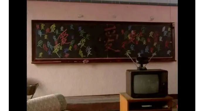 ▲《过把瘾》中王志⽂扮演的角色将家中⿊板写满“爱”字。