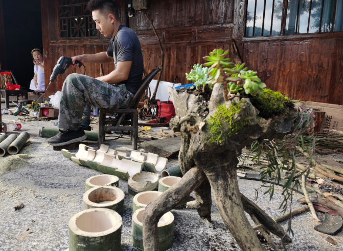 ▲2020年8月1日，陈林帮助曹坤家自制手工艺品，材料都是山上找来的树枝、树根等“废料”。新京报记者 王颖 摄