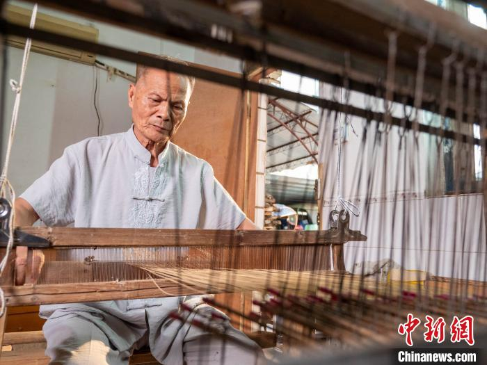 图为邱广初编织扇面。　邱燕珍 摄