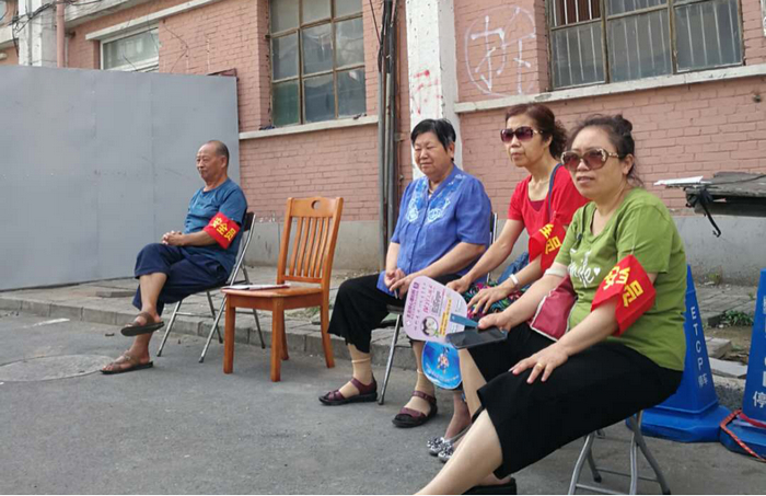 从8月初开始，住户别上“安全员”红袖套，每天在值班守楼。 （受访者供图）