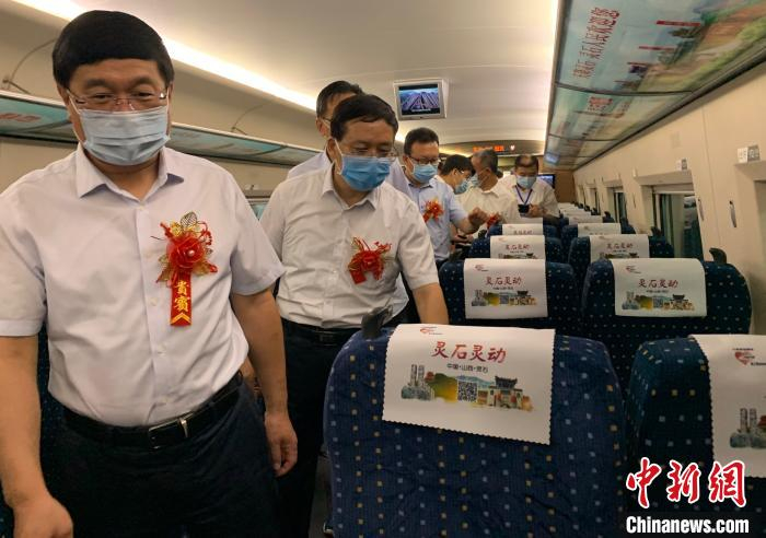 走进“灵石号”高铁冠名专列，车厢内的头枕巾、桌板贴、海报、车门贴、行李架贴、字幕等处处彰显灵石元素。　刘小红 摄