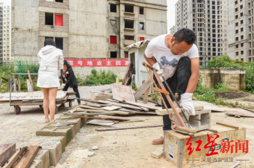  小区业主正在劈柴生火