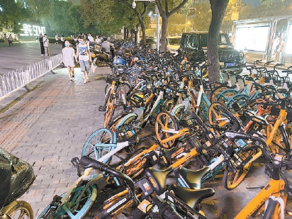  在三里屯SOHO附近，过度投放的共享单车堆积在人行道上，挤占行人通行空间。