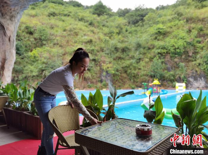 图为杨贵秋整理休闲农庄内的座椅。　周燕玲 摄