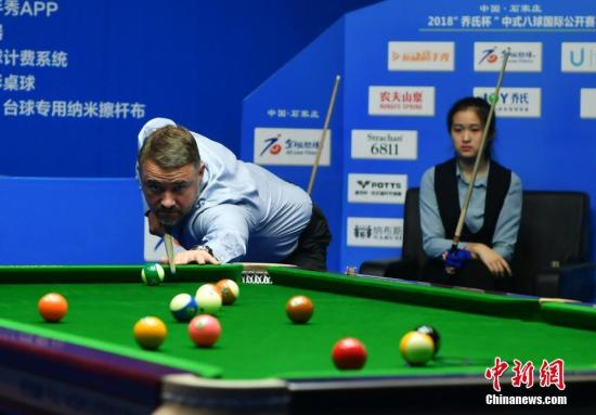 资料图：中国·石家庄2018中式八球国际公开赛开赛，被誉为“台球皇帝”的亨德利现身河北石家庄赛场，与河北省第15届运动会群众组台球比赛的女子组冠军王也互相切磋交流。 图为两人同场“竞技”。中新社记者 翟羽佳 摄