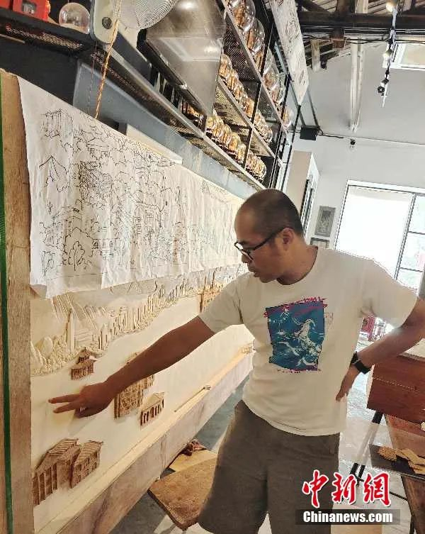 何光明针对定制软木画创作的画面进行构图指导。受访者供图