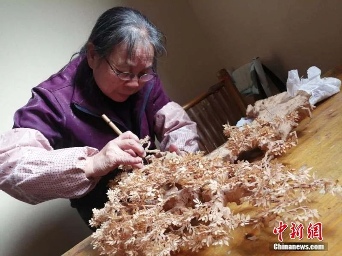 吴瑞珍从艺50余年，擅长“树”制作工艺，主攻创制作各种造型的花草树木系列雕刻艺术，灵活技巧地创作出形态各宜的花草树木的景观图案，是软木画界制树工艺圣手。中新社记者 张斌 摄