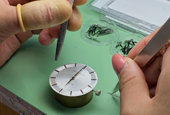 ▲工人在安装表盘零件，摄影：安舜