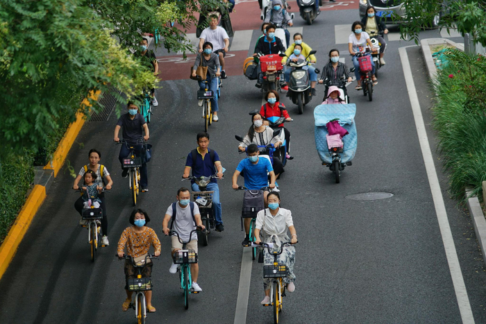 早高峰时段，不少市民选择骑自行车、电动车出行。摄影/新京报记者 裴剑飞