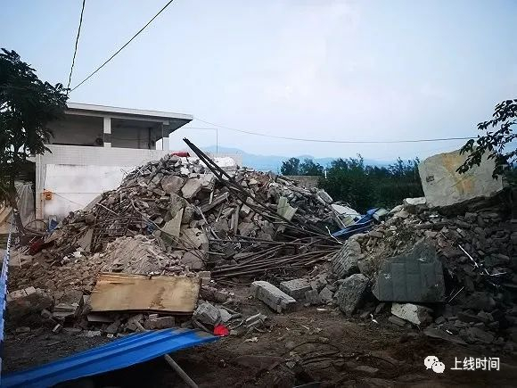 废墟中被清理出的石块堆放在路边。摄影：牛其昌